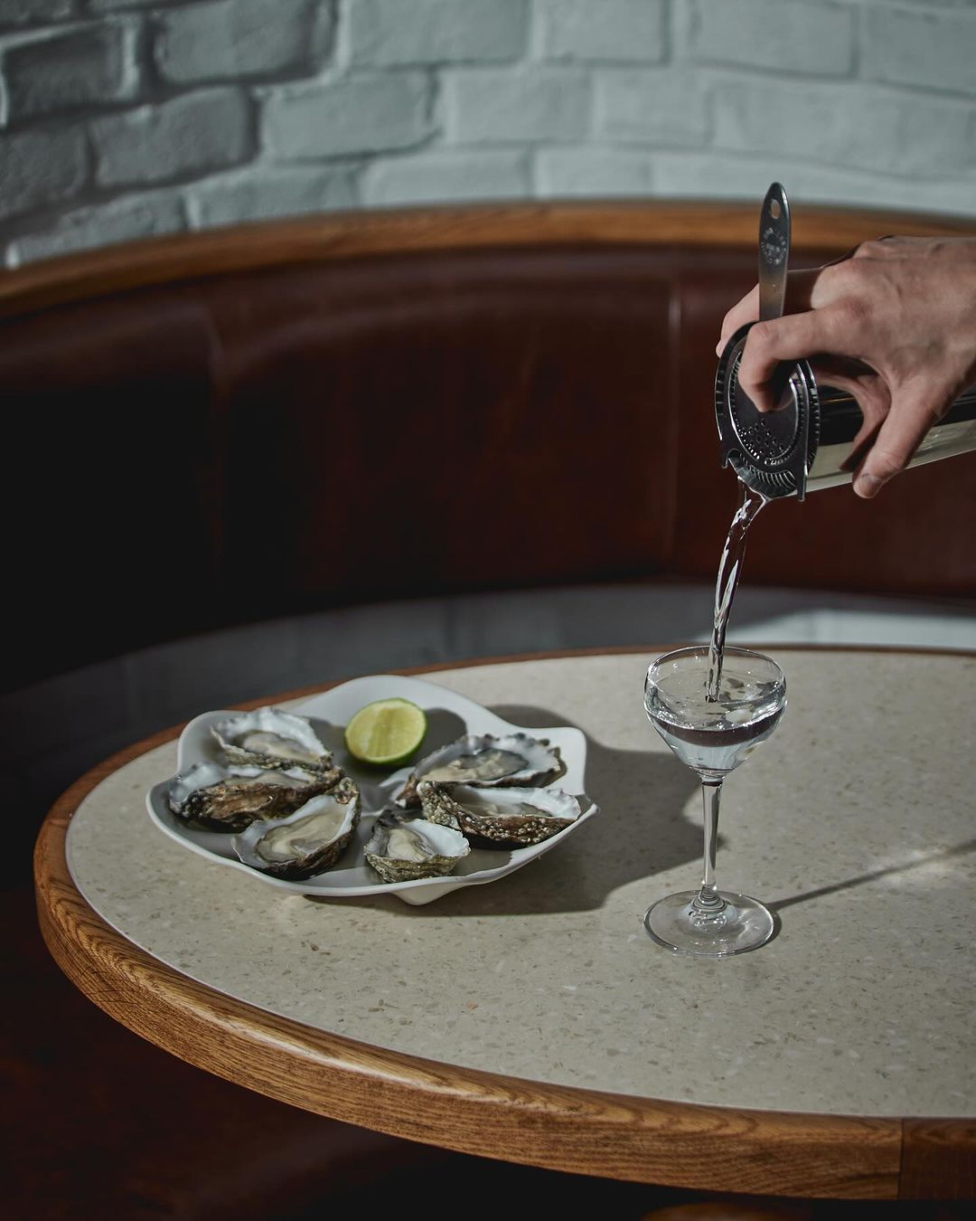 satin white oyster dish with oysters au naturale, lemon garnish, dirty martini, lime